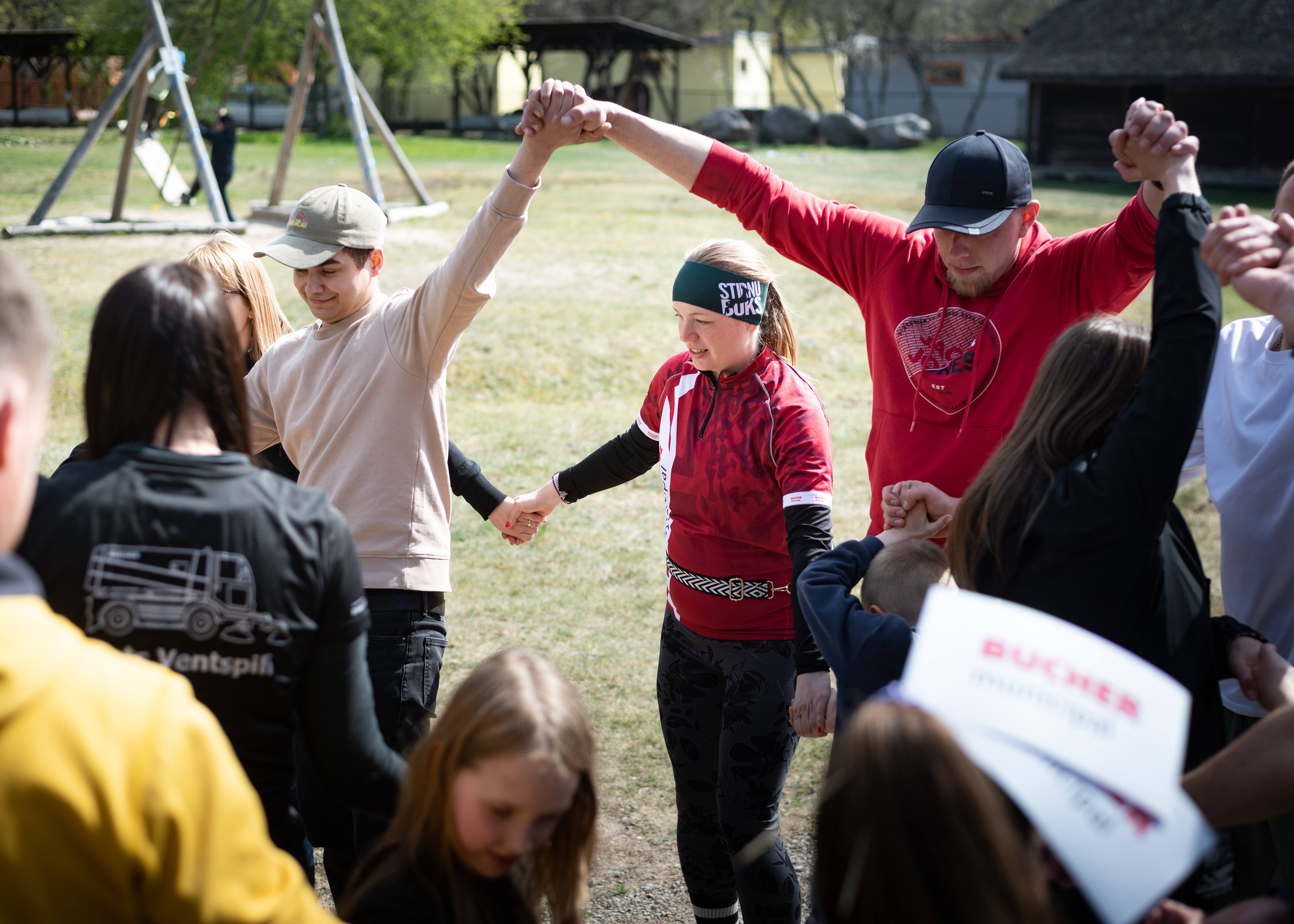 Participants joining hands during an outdoor team activity